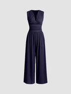 Full-length side view of the camel party jumpsuit, emphasizing the sculpted fit through the waist and relaxed trousers.