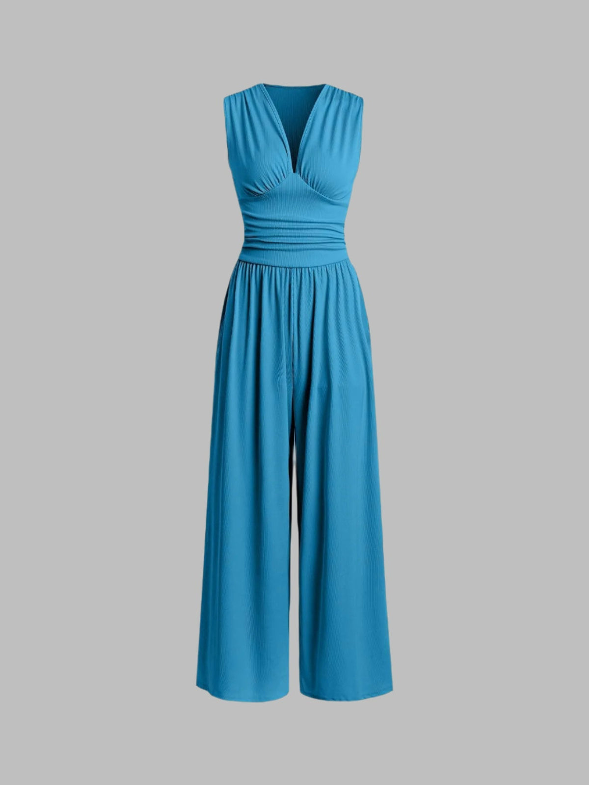 Lifestyle shot of a woman confidently wearing the beautiful blue sleeveless jumpsuit at an evening event.