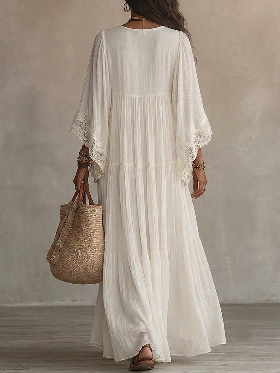 Close-up detail of the white lace trim on the deep V-neck and batwing sleeve of the elegant batwing dress.