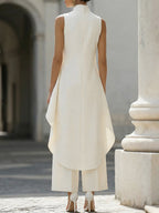 Model smiling and looking over shoulder in a vibrant colored wide-leg jumpsuit, showcasing back design.
