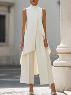 Close-up of the high-neck and asymmetrical panel detail on the black sleeveless jumpsuit.